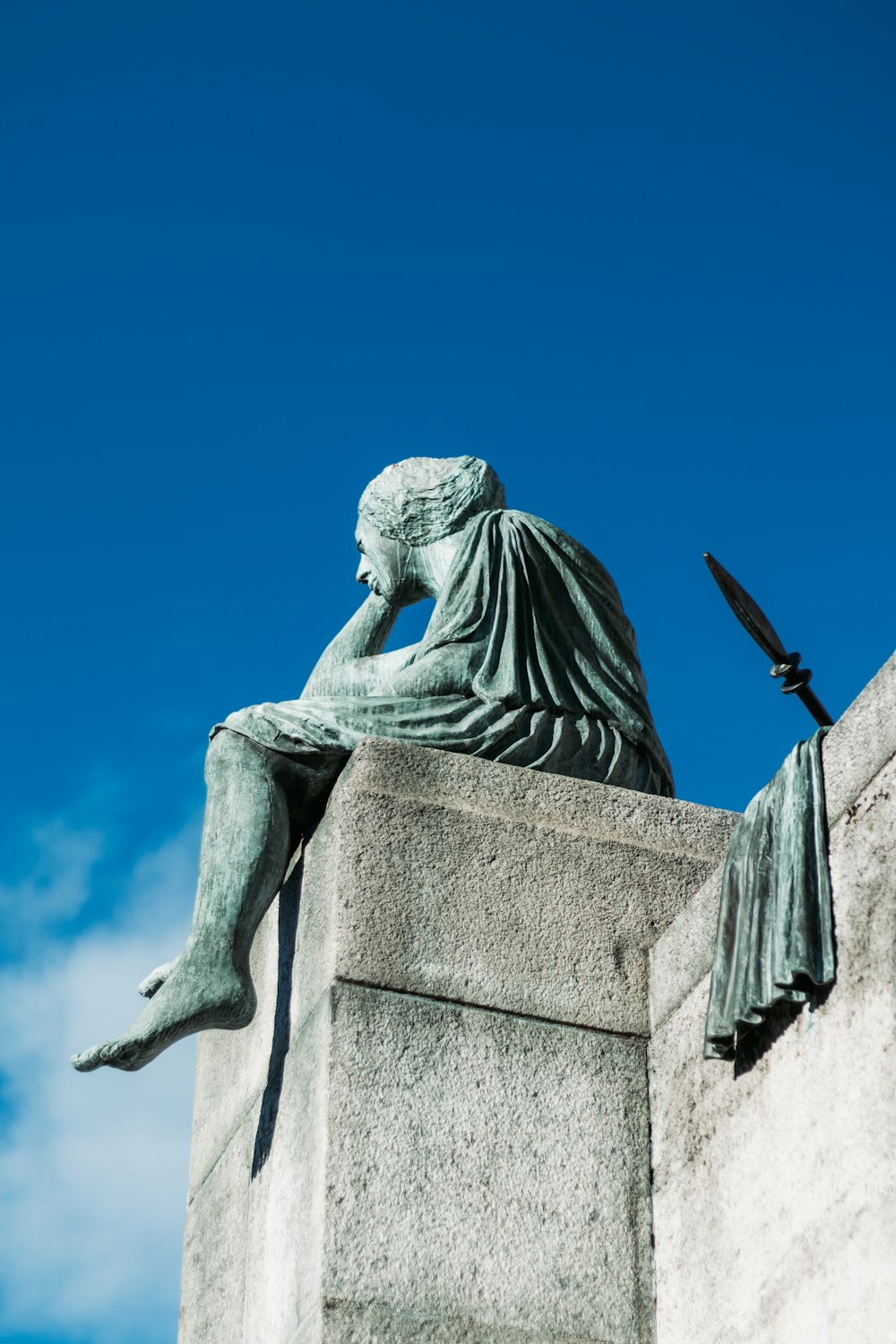 statue of man sitting on building