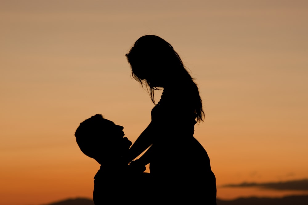 silhouette of man carrying the woman photography