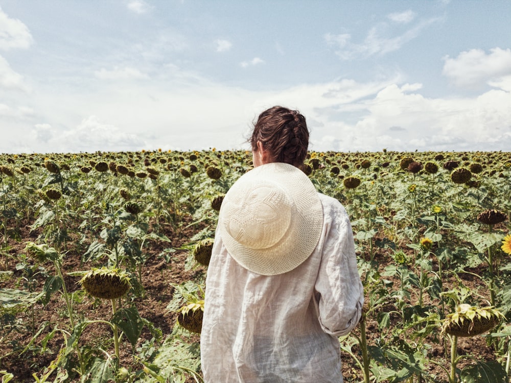 woman standing on green-leafed plant field at daytime