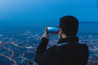 Close-up of the iPhone camera array reflecting city lights at dusk.