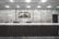 An empty reception desk with a marble finish is situated against a backdrop of polished stone walls. A decorative wall map and signage labeled 'Reception' are mounted above the desk. The lighting is soft and evenly distributed across the room.