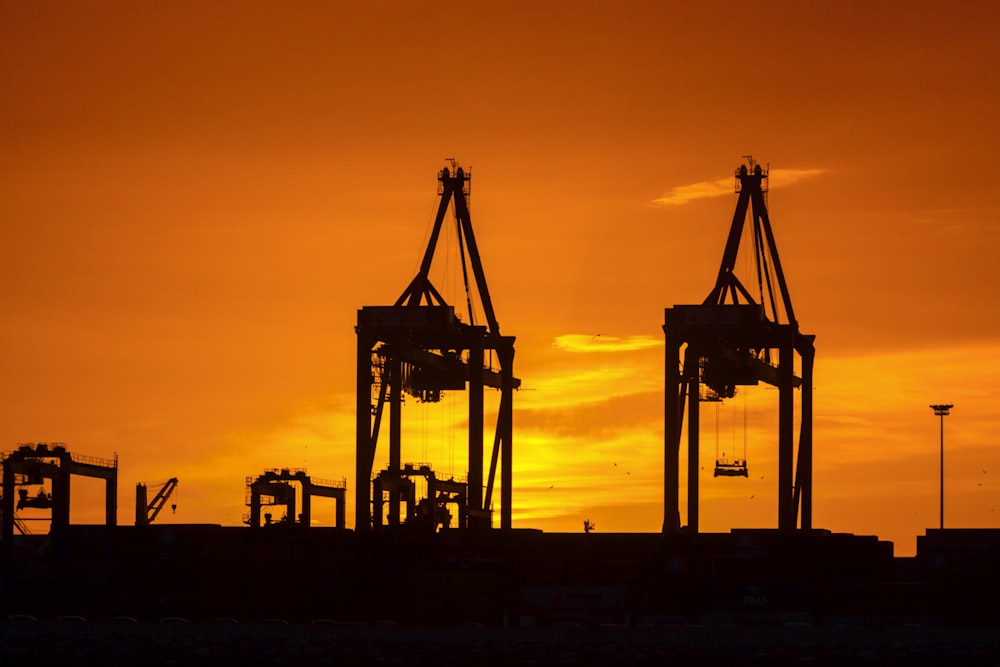 silhouette of two black metal industrial machine