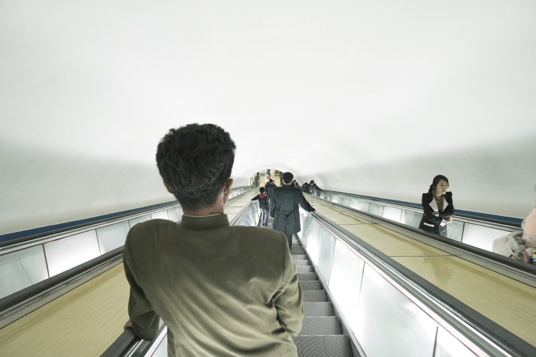 man riding escalator, North Korea Metro