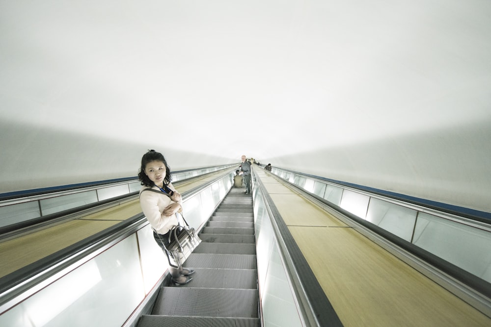 Frau steht auf Rolltreppe