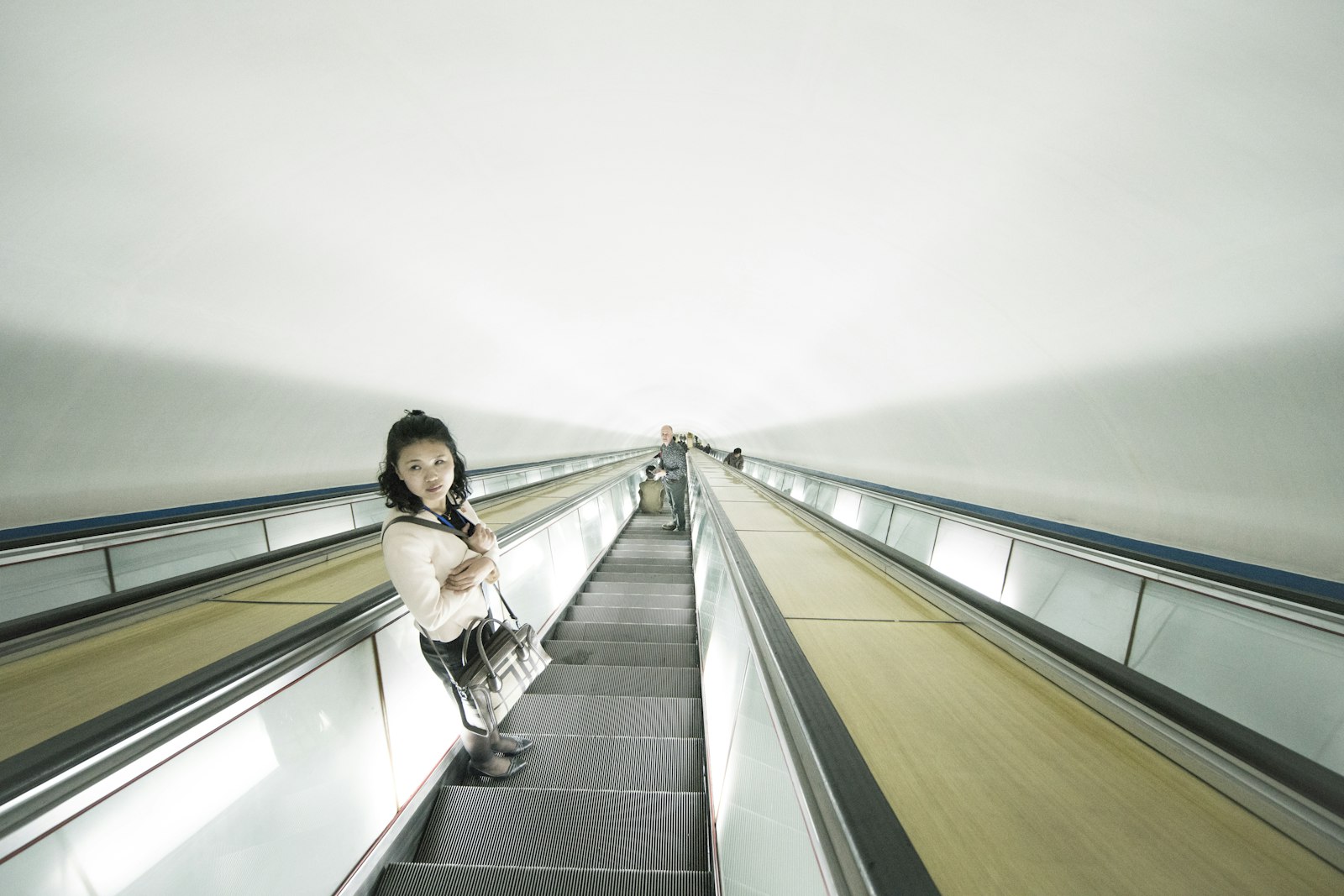 Sony a7R II + Canon EF 11-24mm F4L USM sample photo. Woman standing on escalator photography