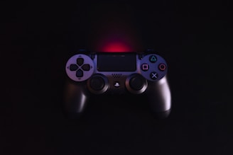 Dark-themed background with glowing joystick and gamepad icons in violet and blue.