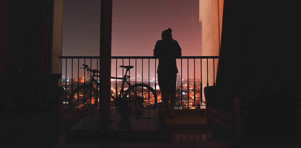 silhouette of person beside the bicycle