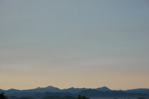 A serene early morning trail runner surrounded by soft pastel-colored mountains.
