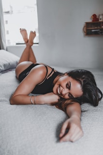 smiling woman lying on the bed