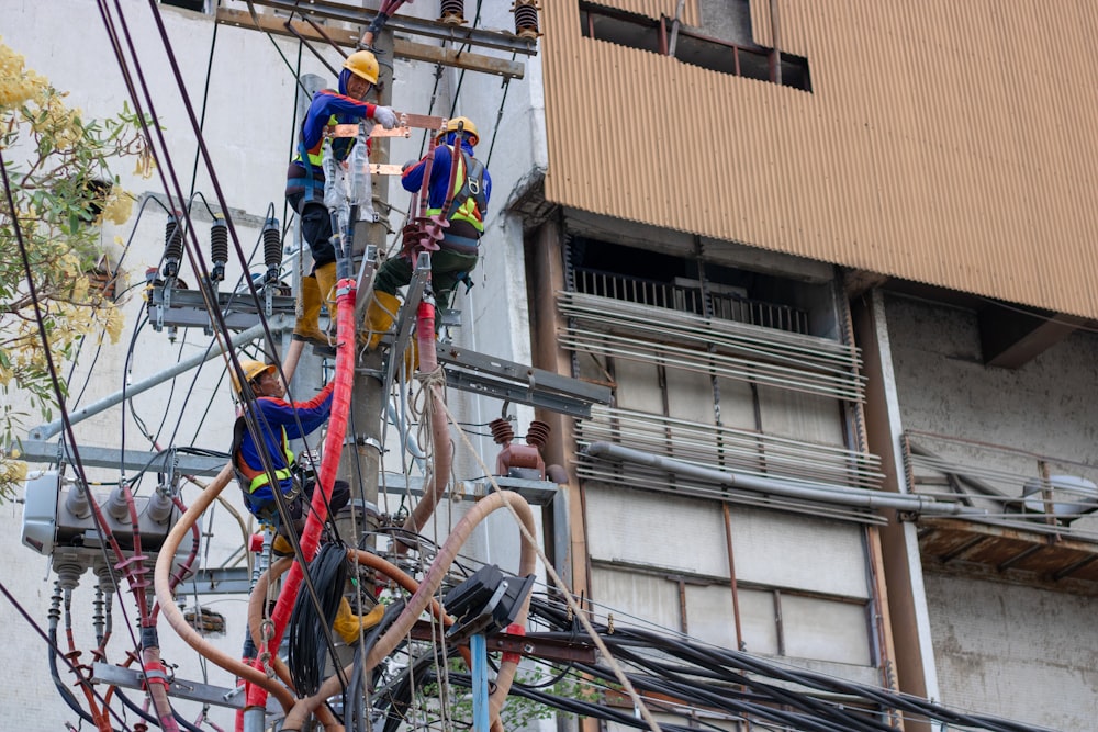 grupo de pessoas fixando os fios no poste