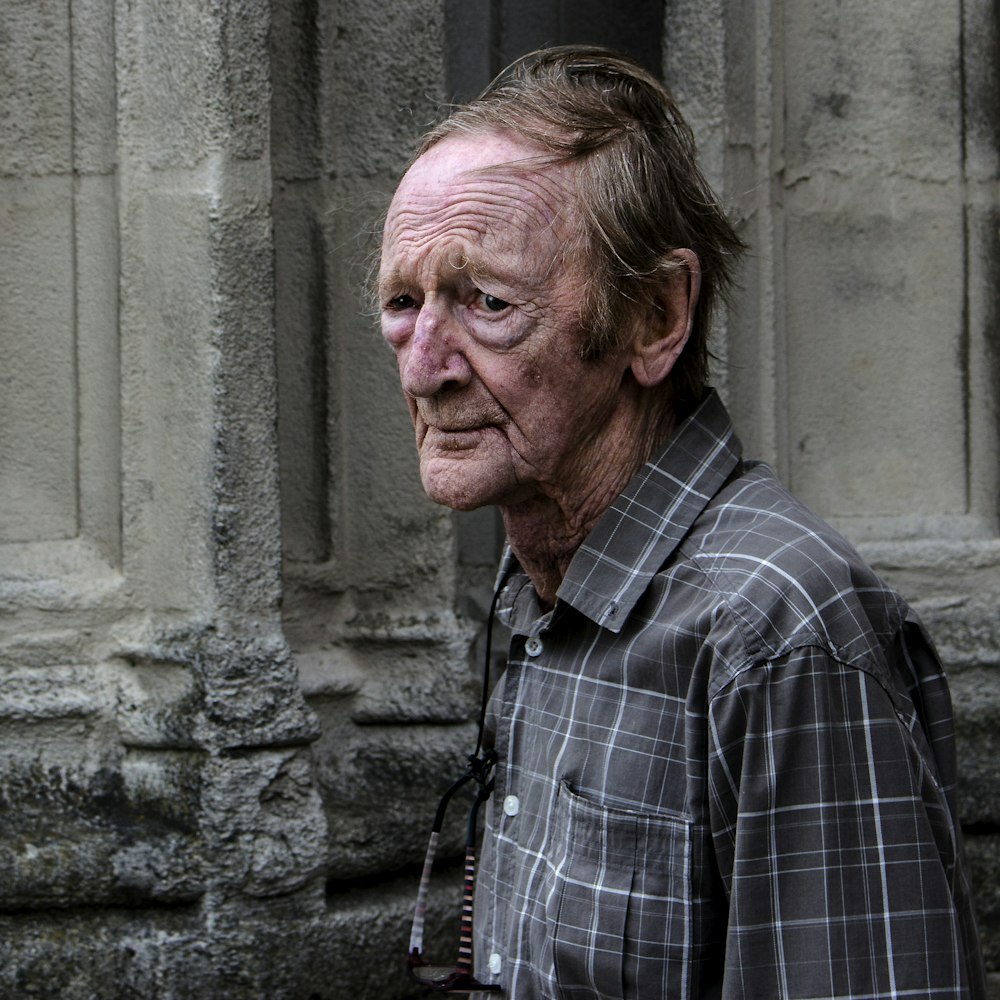 man standing near gray building