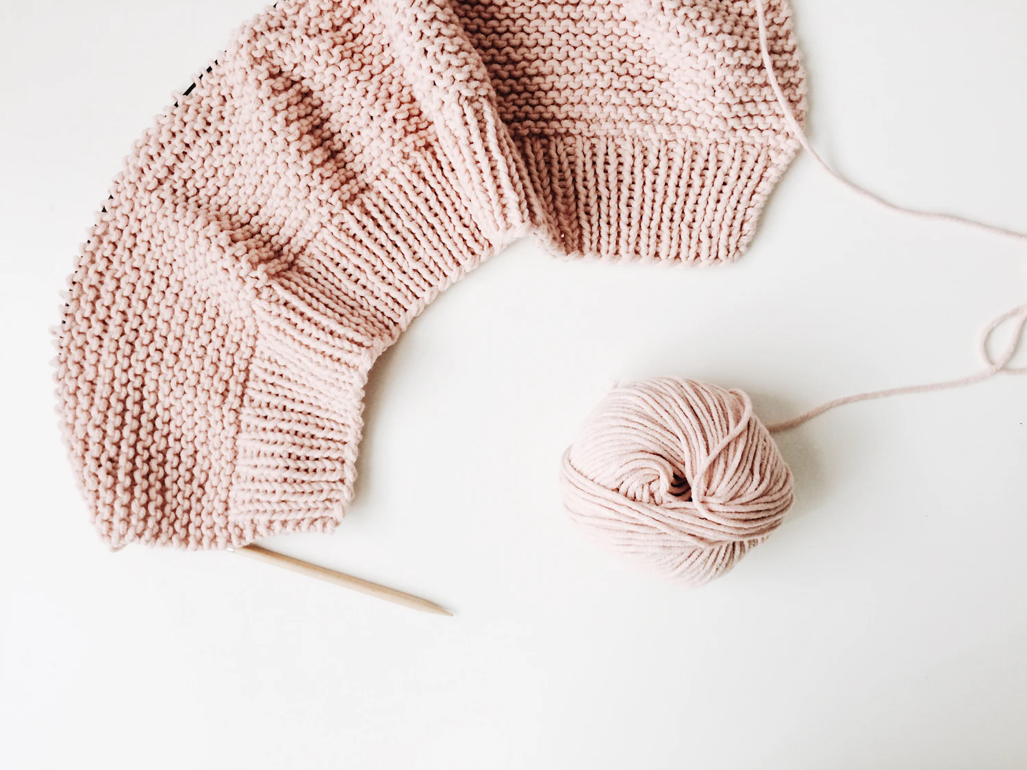 A pale knitted blanket filling the frame, stitch by stitch