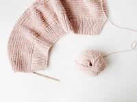A pale knitted blanket filling the frame, stitch by stitch