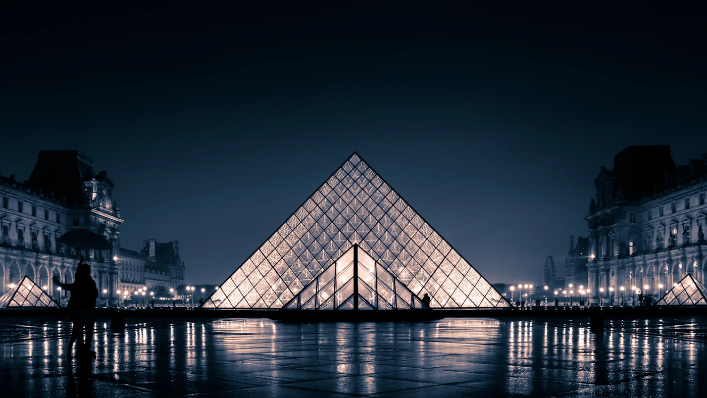 The Louvre Museum glass pyramid in Paris at dusk
