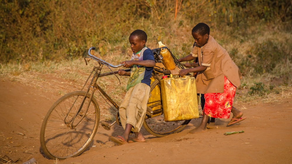 dos niños usando una bicicleta marrón con carga