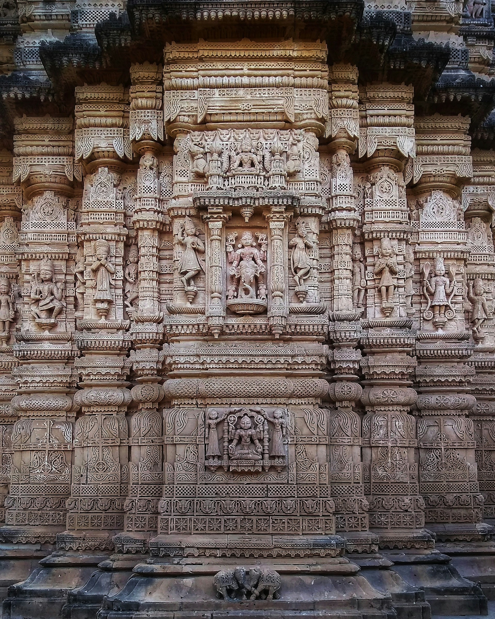 Close-up of intricate carvings on the temple walls of Kunda Dham, showcasing the craftsmanship and spiritual symbols.