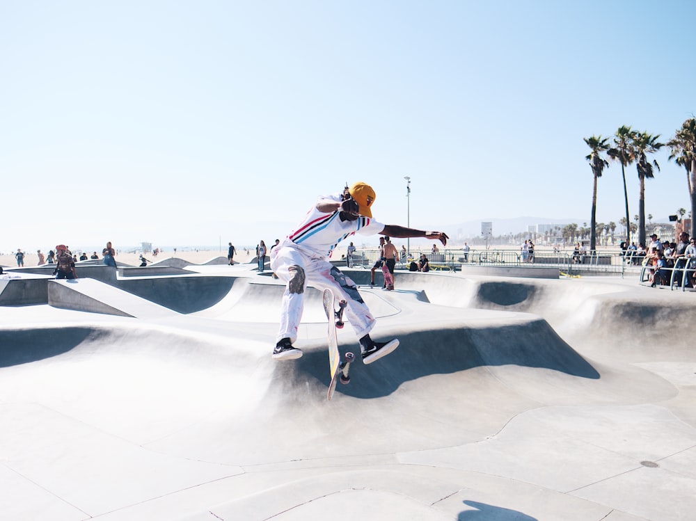 man jumping wearing white track pants and jacket during daytime