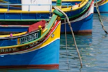 Colorful fishing boats bobbing in the clear waters of Marsaxlokk harbor.