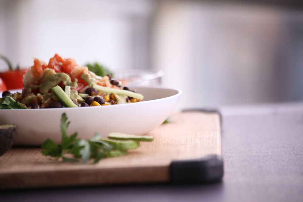 food in white bowl on brown wooden board