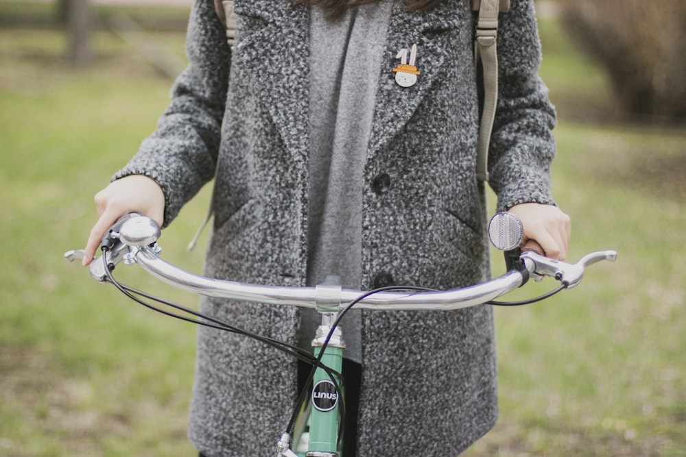 woman gray coat riding bike