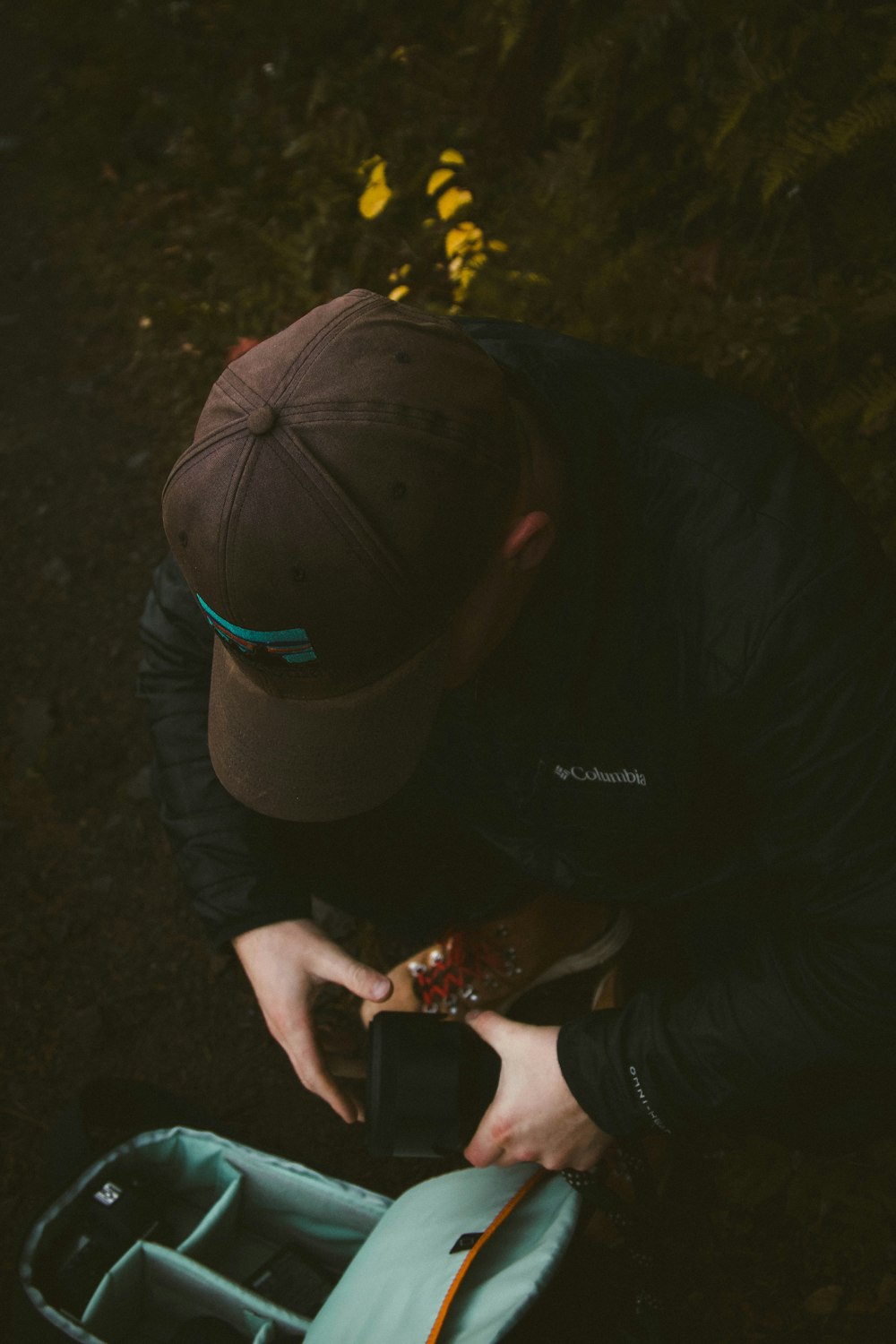 man wearing black and teal cap