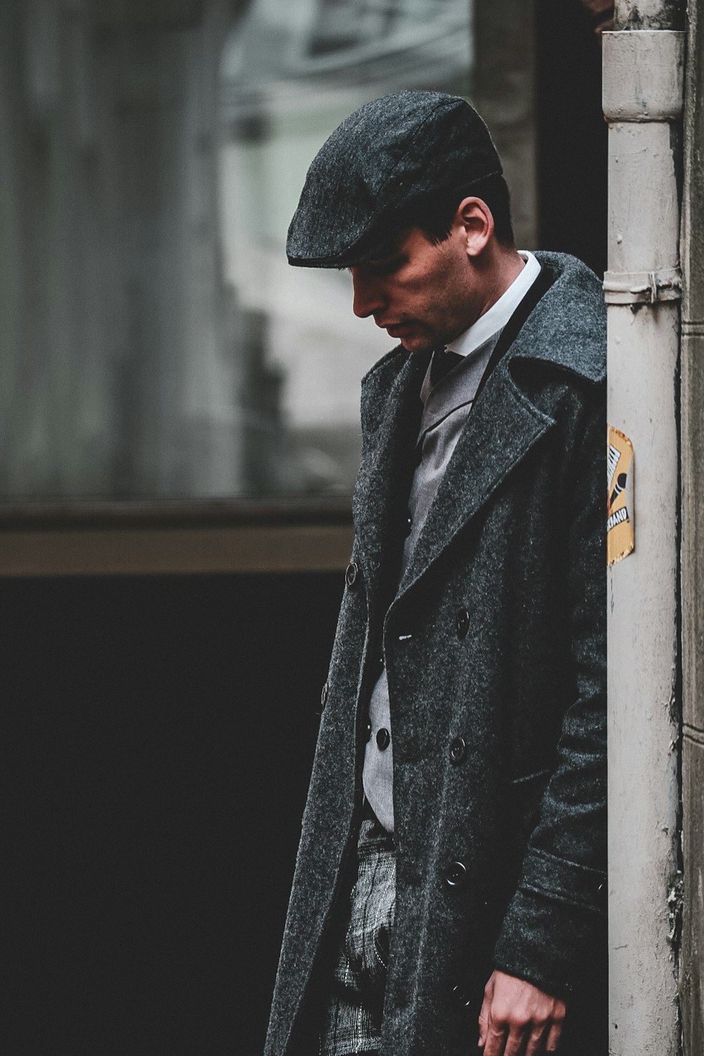 hombre con gorra plana gris y abrigo