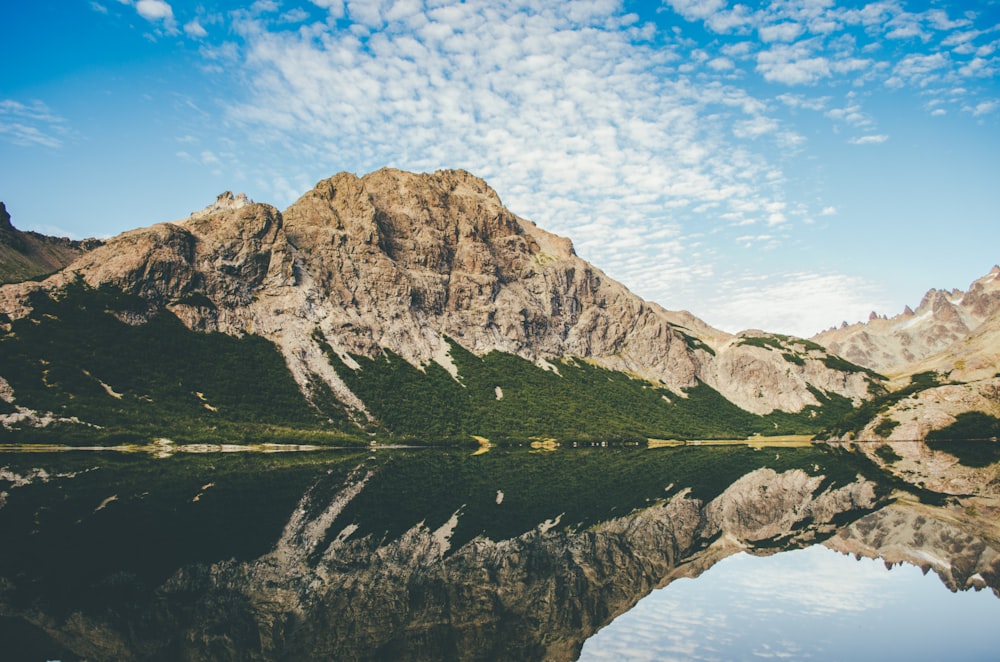 Montaña marrón al lado del cuerpo de agua