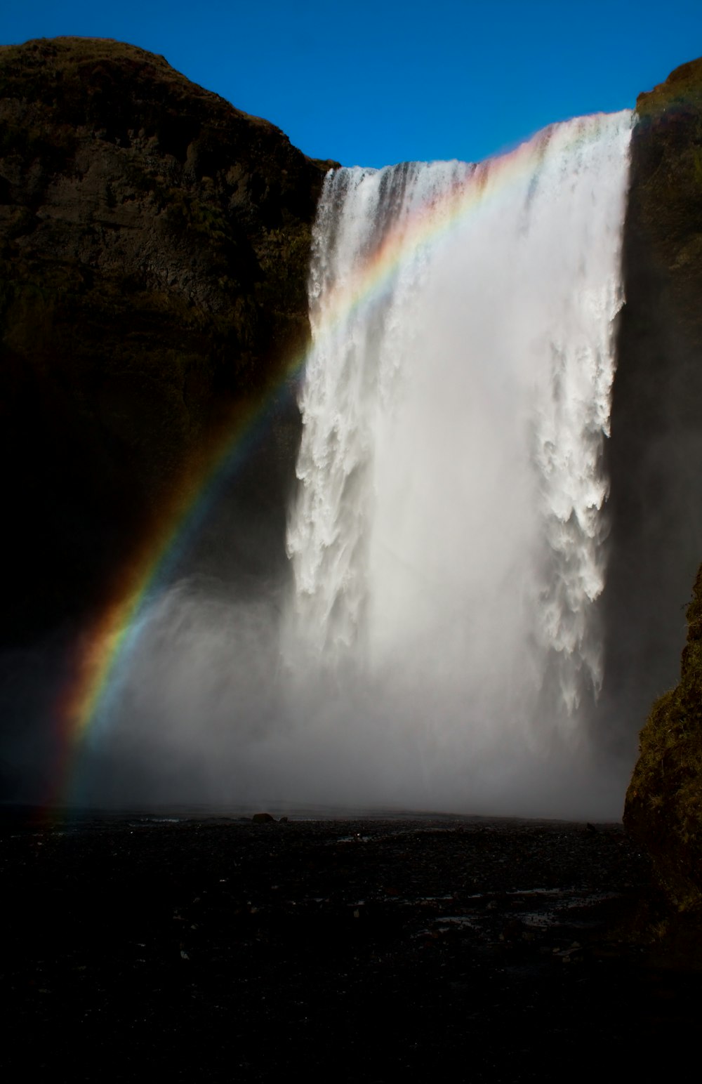 low-angle photography of waterfalls and rainbow