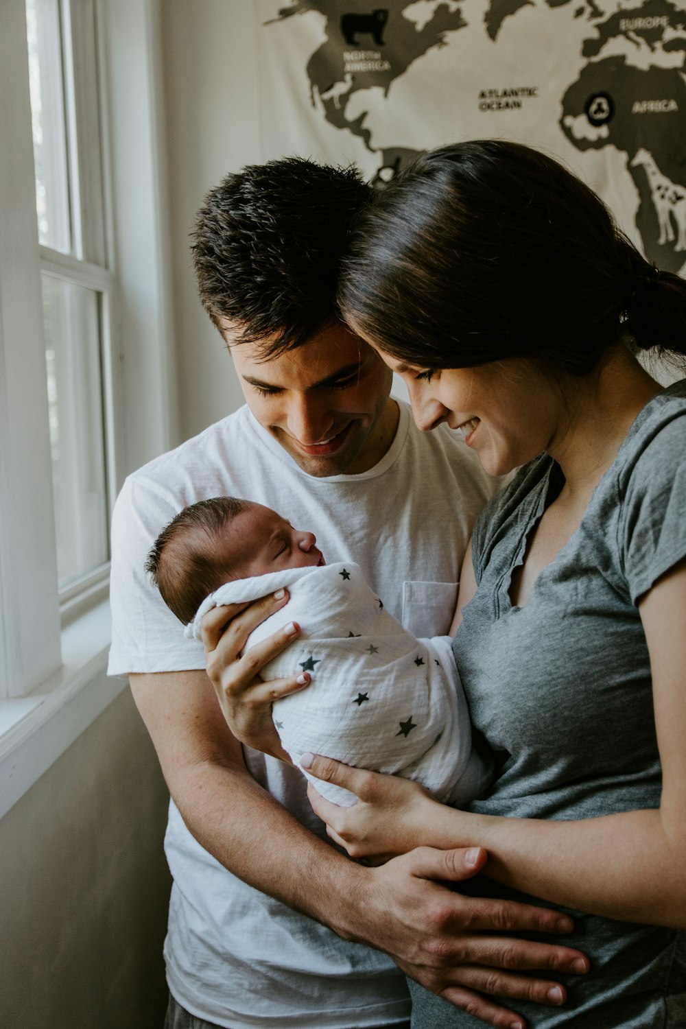 微笑む男の横で赤ん坊を抱く女性