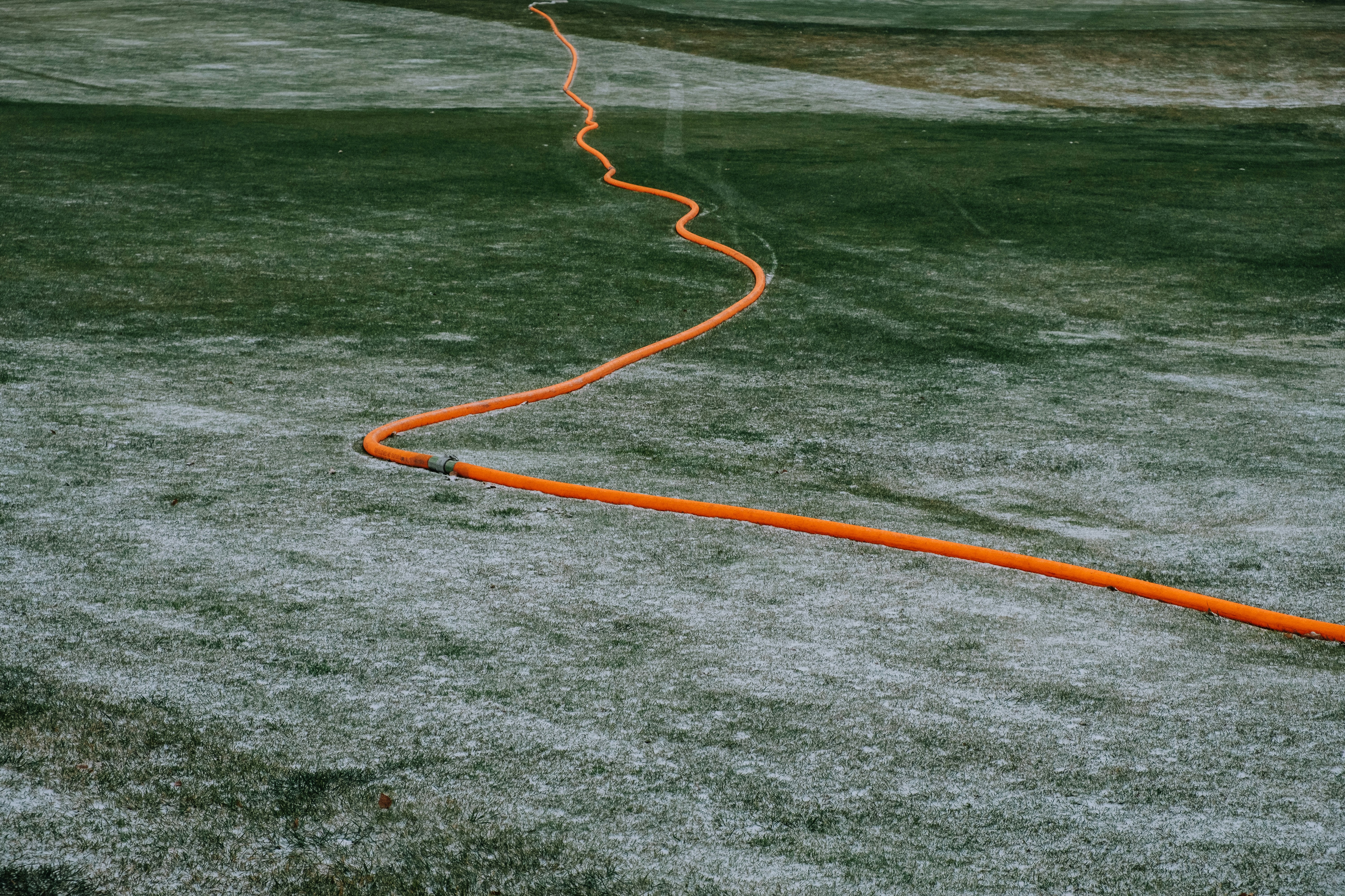 orange hose on body of water