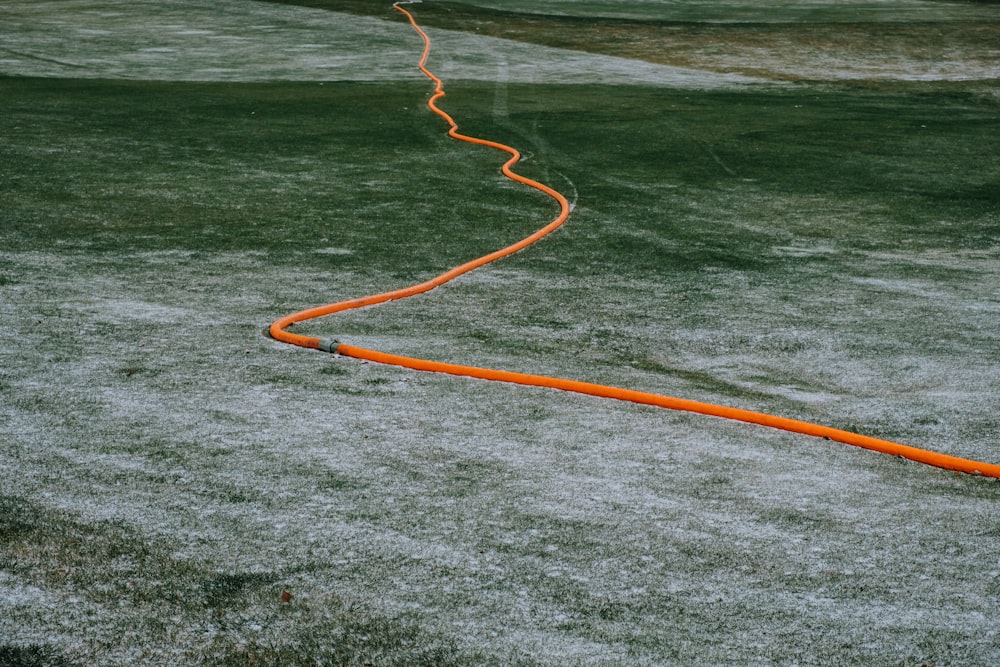 orange hose on body of water