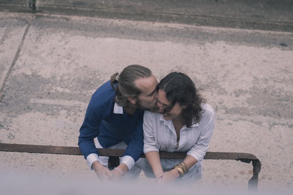 man kissing woman on cheek during daytime