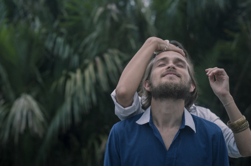 woman touching man in blue shirt's forehead