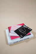 A neatly arranged stack of colorful sales brochures on a wooden desk.