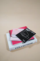 A stack of printed digital guides and proposal templates on a wooden desk.