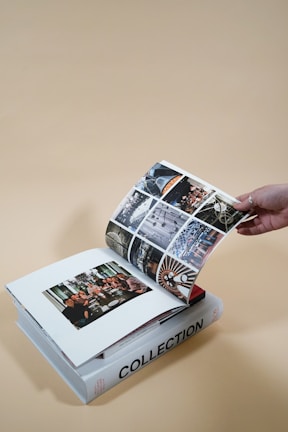 Hands flipping through a photography book filled with technical diagrams and vivid photo examples