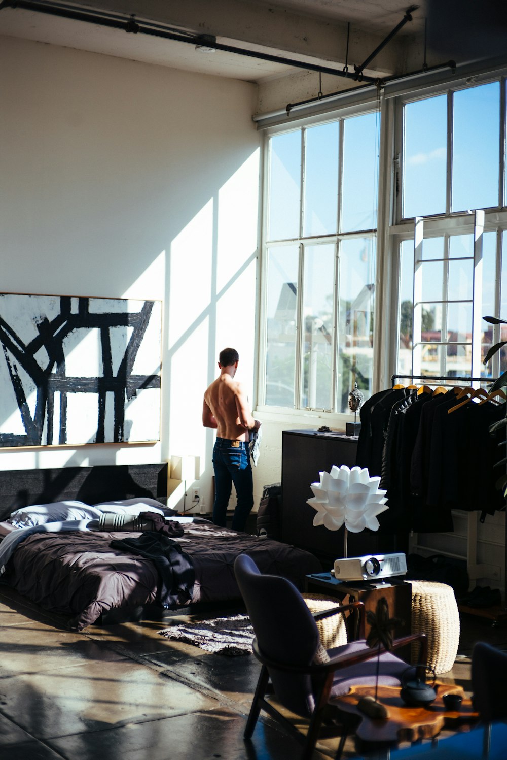 half naked man stands in front of glass window