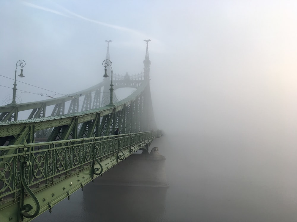 gray bridge covered with fog