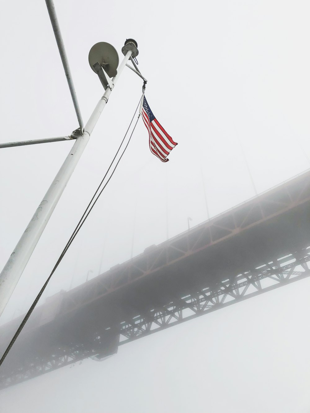 low angel photography of waving USA flag under red bridge