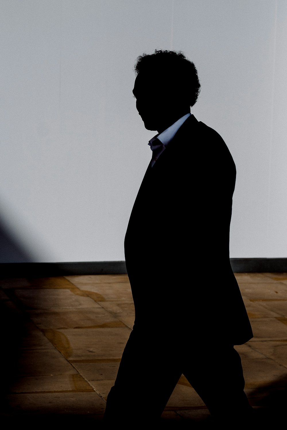 silhouette of man walking inside room