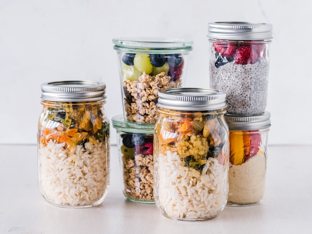 six full clear glass jars on white surface