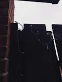Battery-operated string lights draped casually over a rustic wooden fence at dusk.