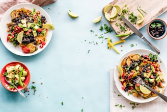 three bowls of salad dish with lemon on table
