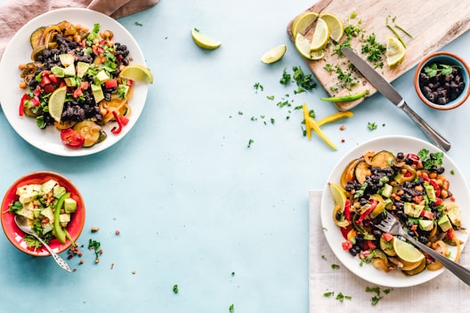 three bowls of salad dish with lemon on table