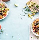 three bowls of salad dish with lemon on table