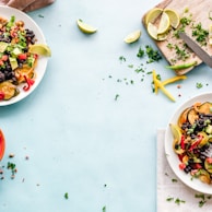 three bowls of salad dish with lemon on table