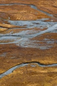 An aerial view of a sprawling African savanna with a winding river cutting through the landscape.