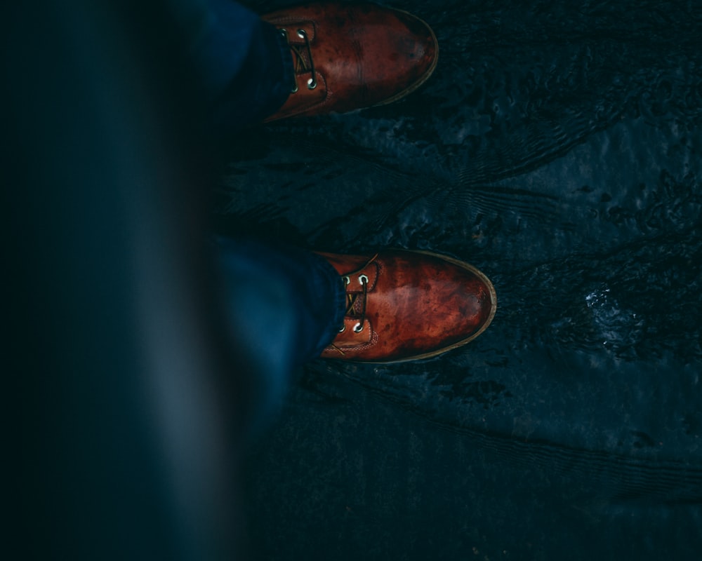 person wearing blue denim jeans with brown leather shoes