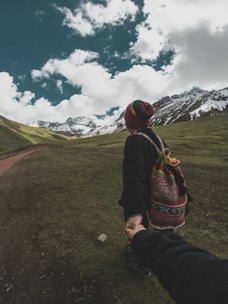 A cheerful companion walking alongside a traveler with mountains in the background.