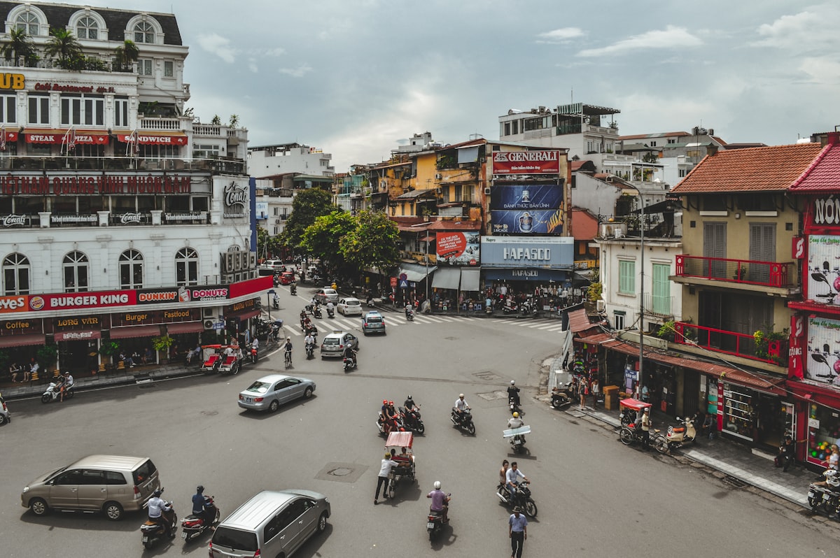 Hanoi May — motorcycles and street life at a busy intersection viewed from a café above the Old Quarter